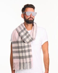 A high-fashion editorial shot of a red tartan cashmere scarf.