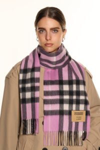 Artisan hands weaving Scottish cashmere on a traditional loom, showcasing premium material.