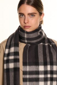 A folded red tartan cashmere scarf in a luxury signature gift box.